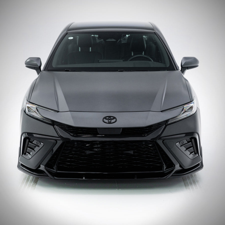 Head-on studio view of a grey 2025-2026 Toyota Camry with the YOFER
front bumper, showing both corner intakes and the full-width mesh grille